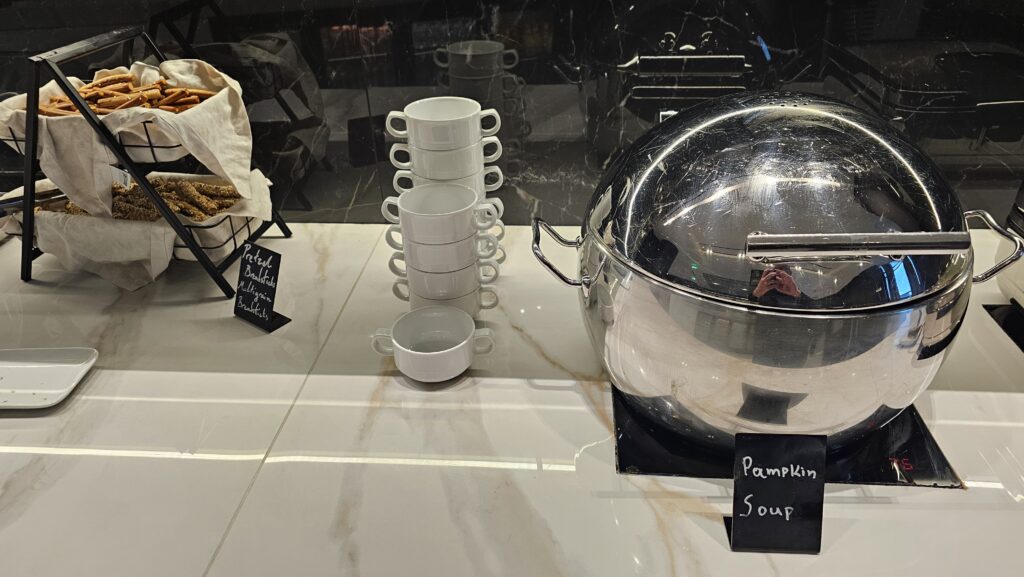 a silver pot and white cups on a counter
