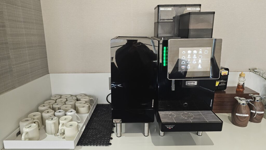a coffee machine next to a tray of coffee cups