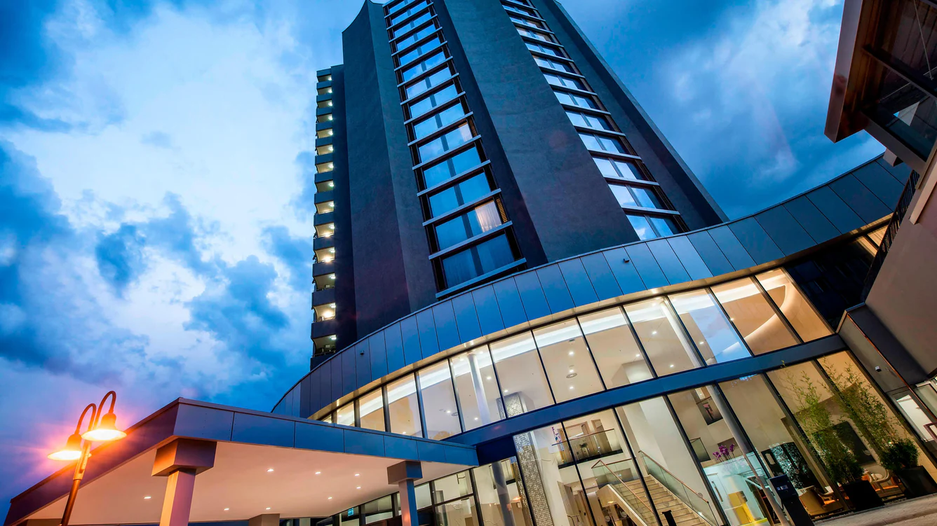 A tall building, Delta Hotels Offenbach, with glass windows.