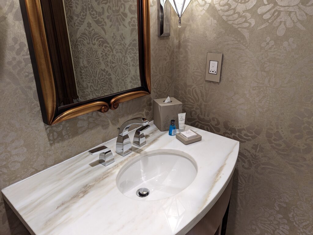 a bathroom sink with a mirror and a wallpaper