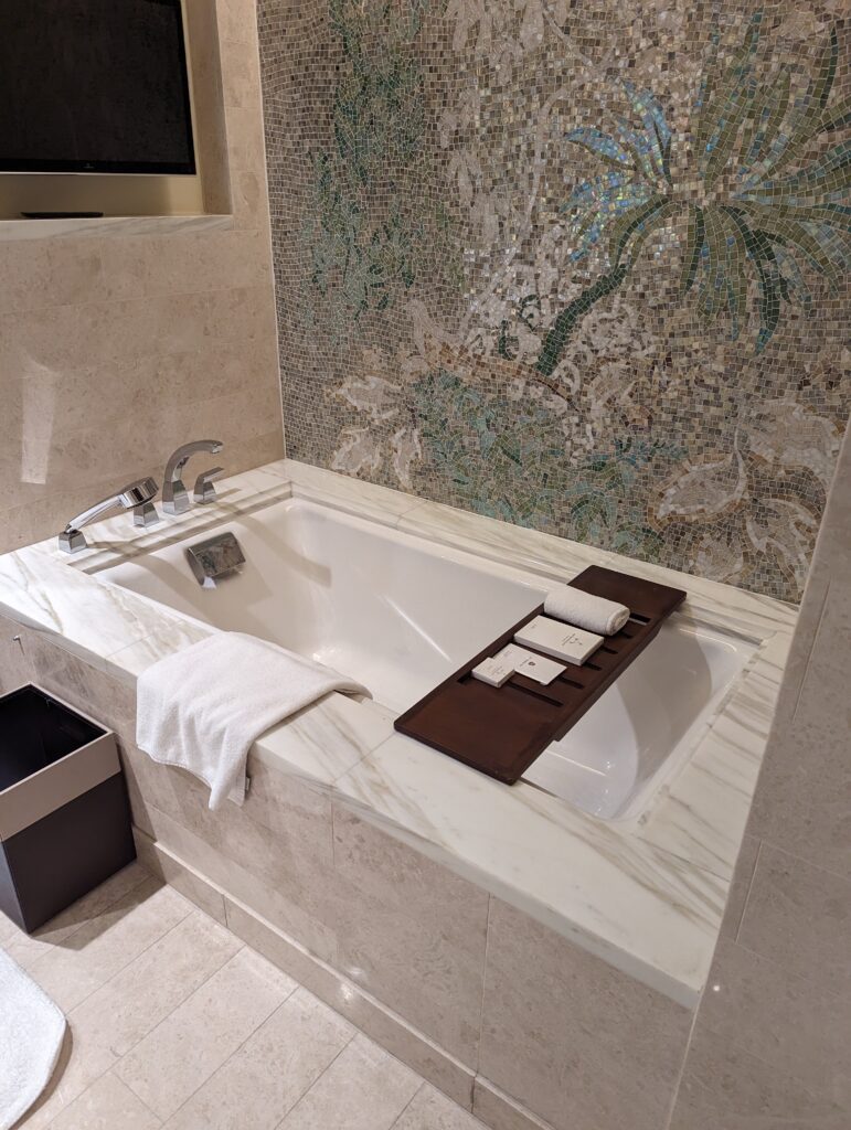 a bathtub with a tray and towels on it