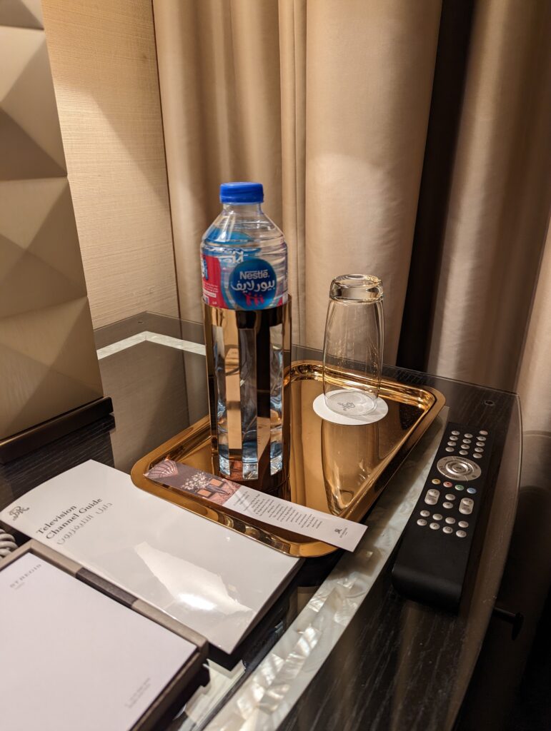 a bottle of water and a glass on a tray