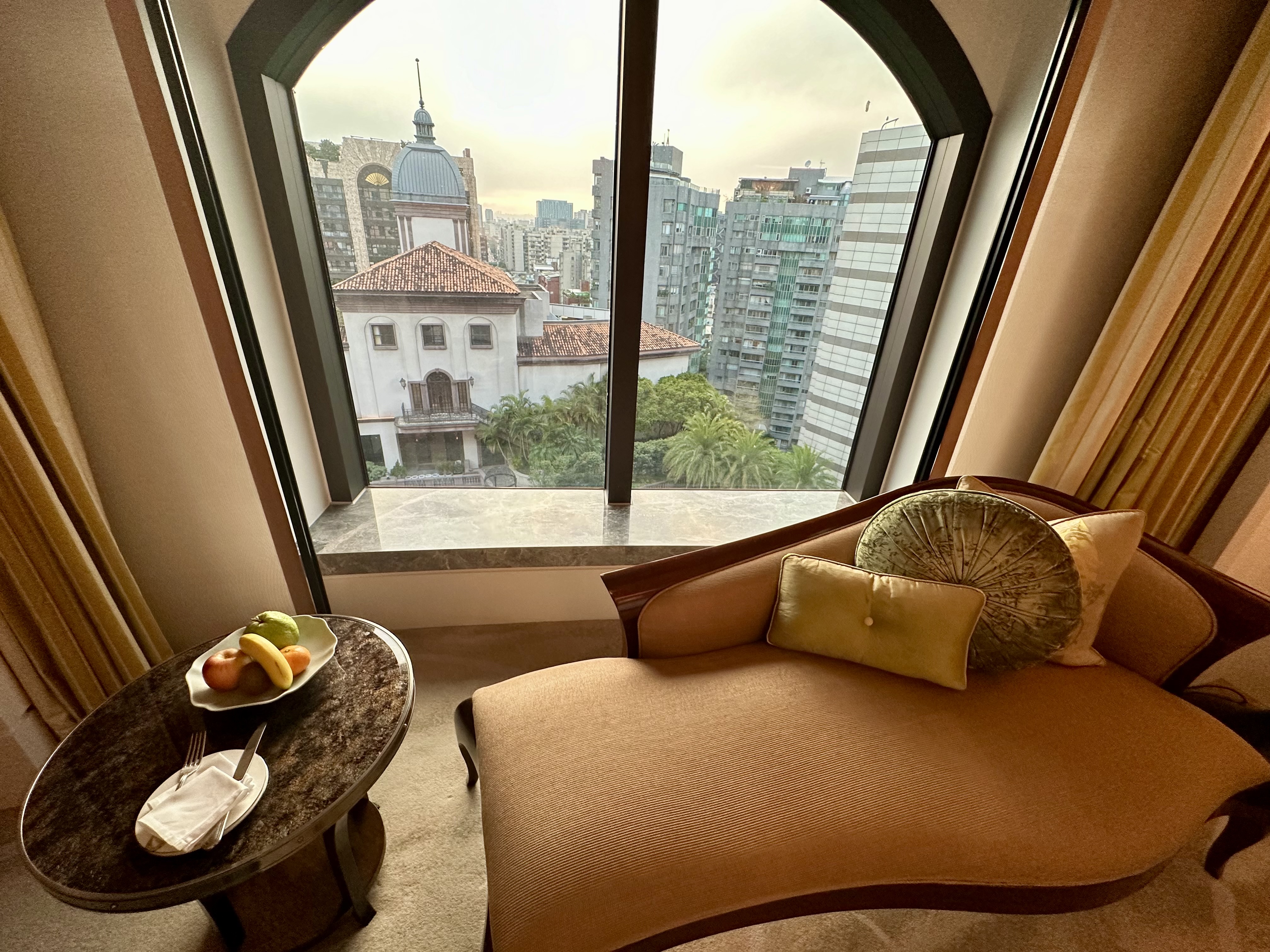 a couch and coffee table in a room with a view of a city at the Mandarin Oriental Taipei