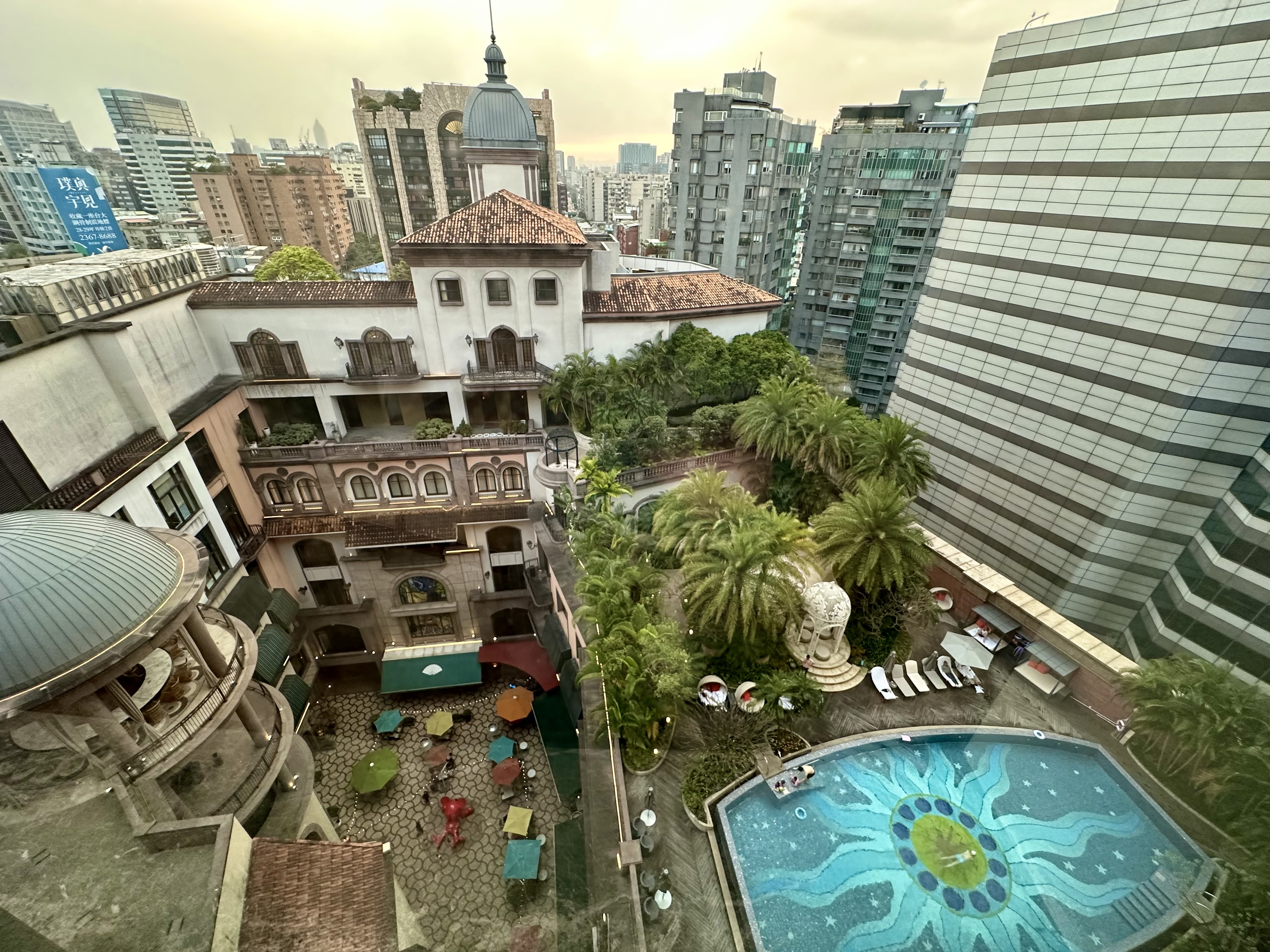 a pool in a courtyard with buildings in the background