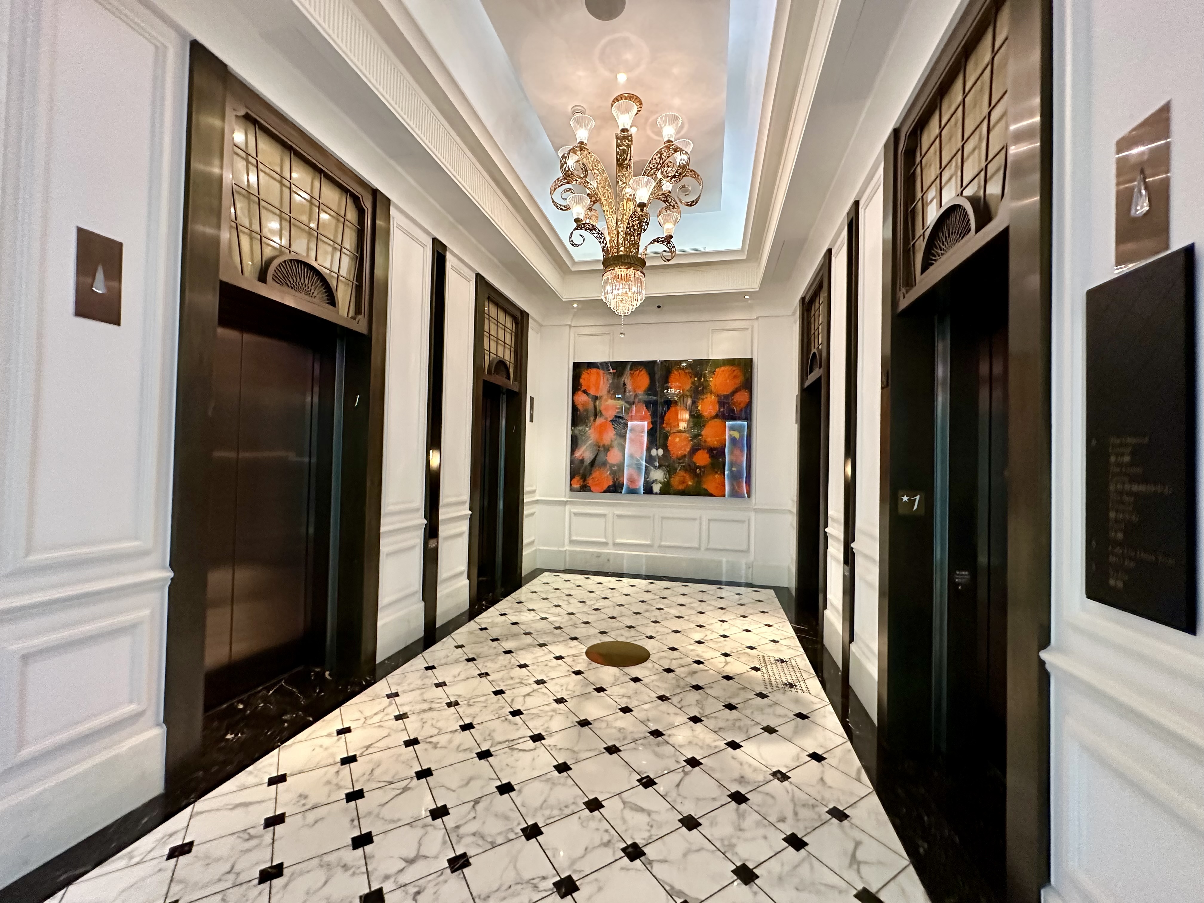 a hallway with black and white flooring and chandelier at the Mandarin Oriental Taipei