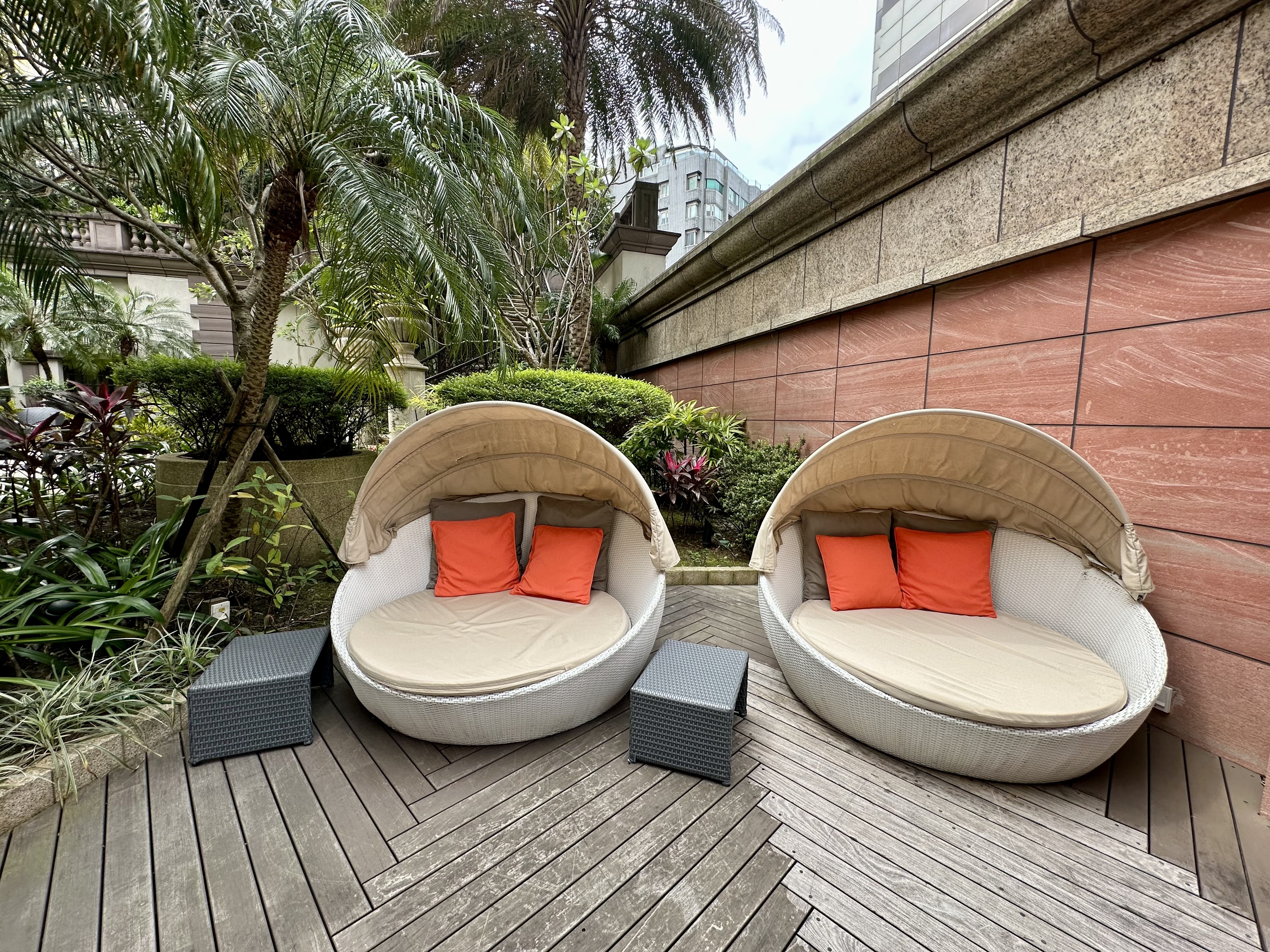 two round chairs with orange pillows on a wood deck