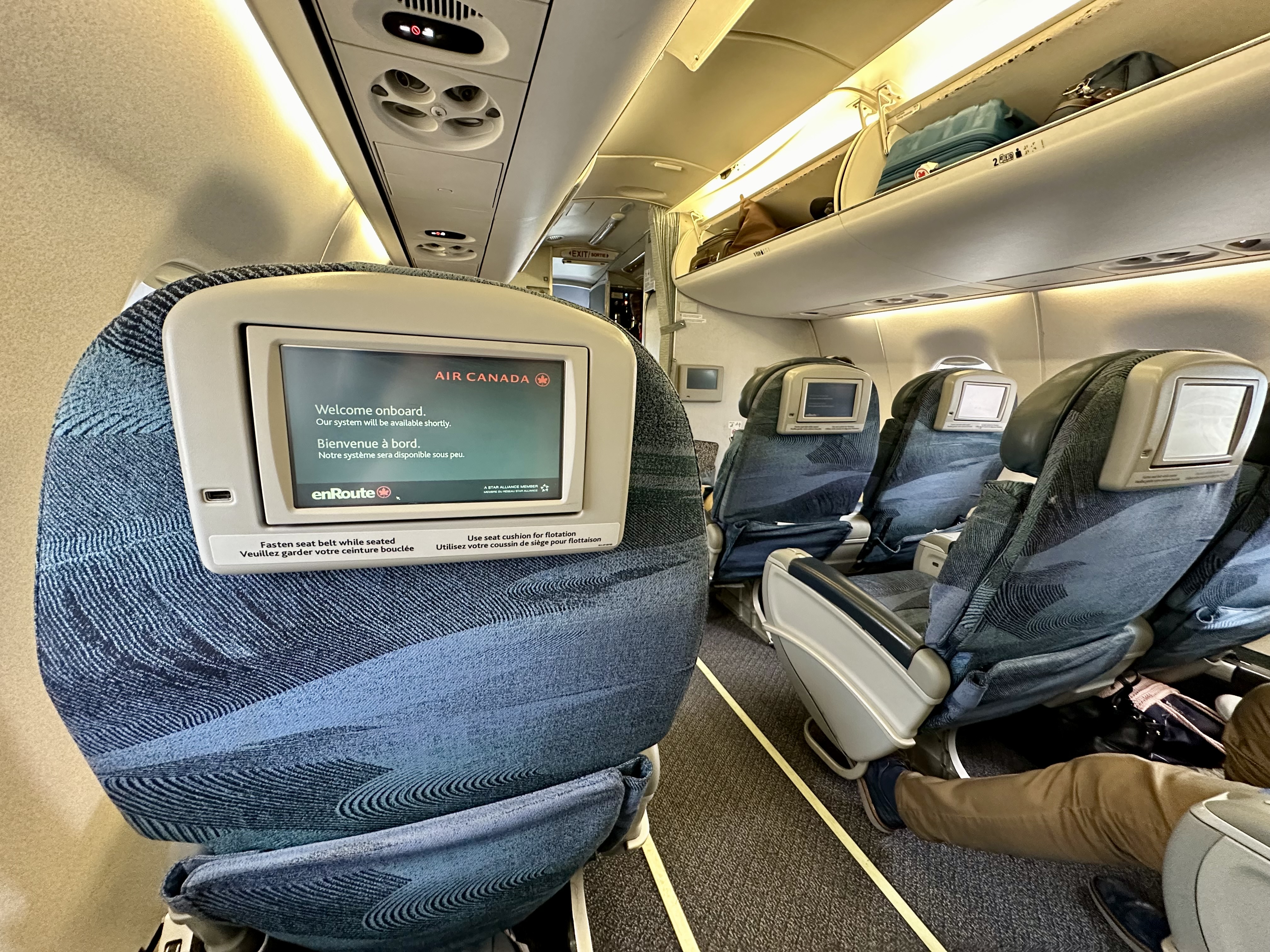 a person sitting in an airplane seat on Air Canada Jazz Business Class