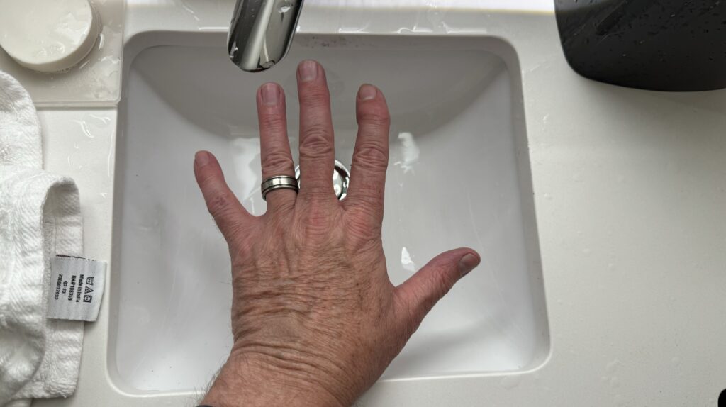 a hand with a ring on a ring in a sink