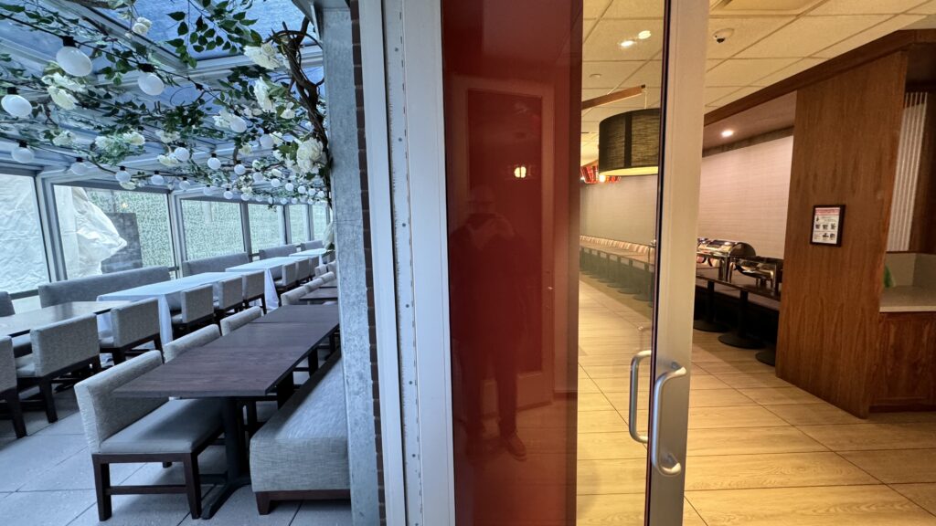 a glass door with a red door and a white wall