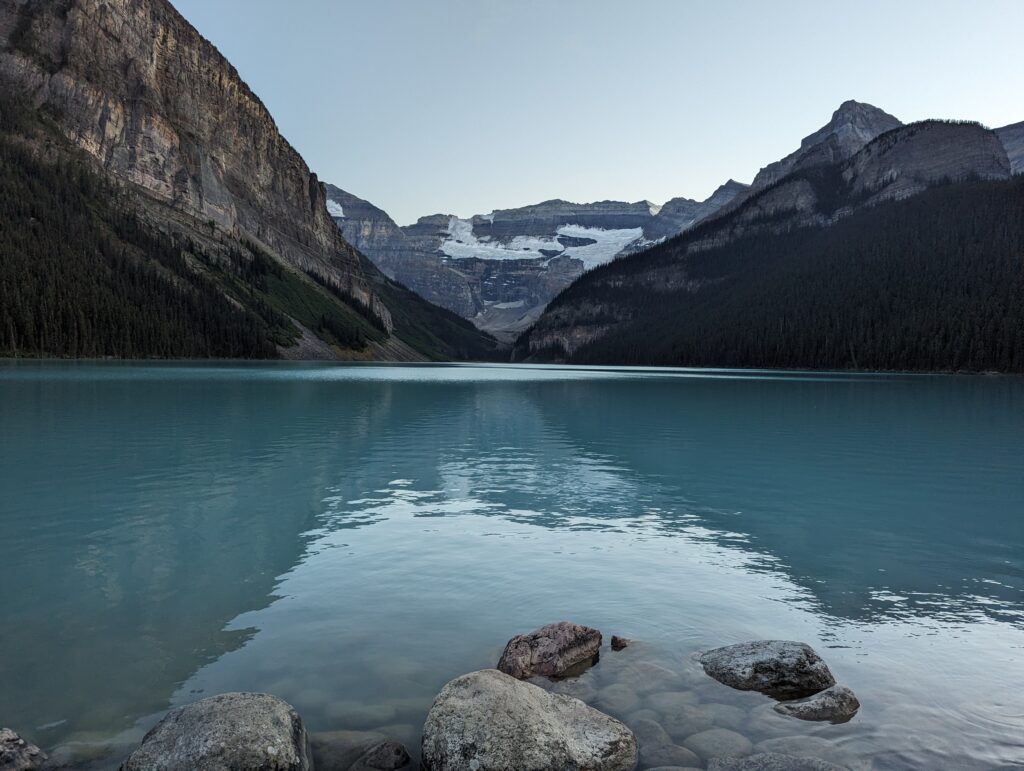 a body of water with mountains in the background with Lake Louise in the background