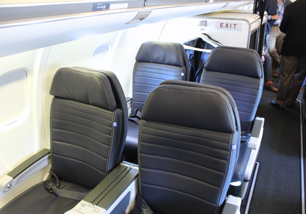a row of seats on an airplane, a United Express CRJ-550 in first class