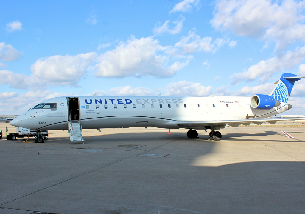 A United Express CRJ-550 sitting on the ramp at St. Louis Lambert International Airport. The aircraft door is open.