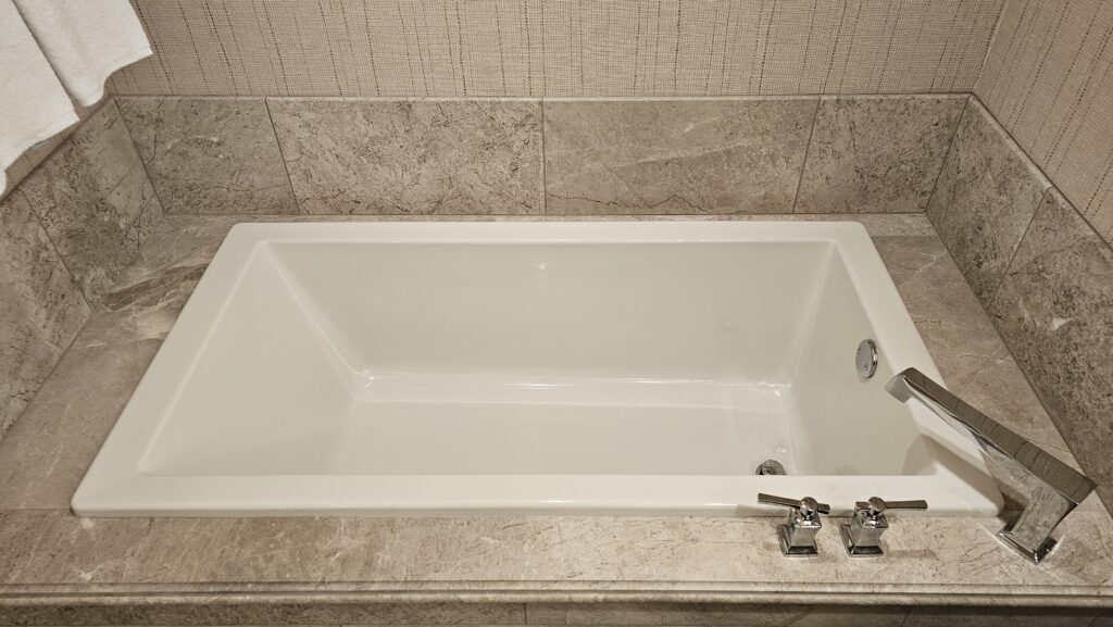 a white bathtub with silver faucets