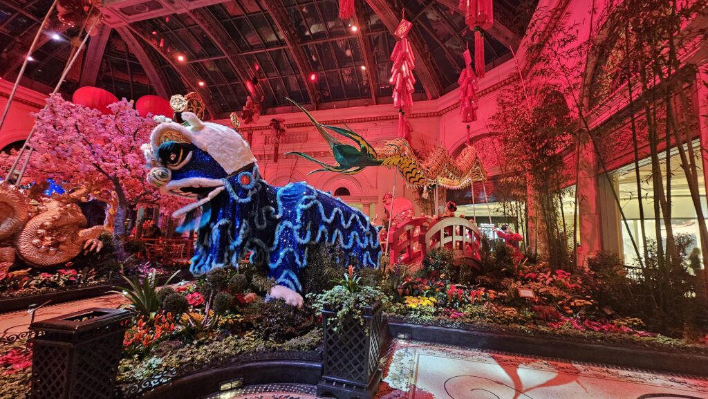 a blue dragon statue in a room with red lanterns