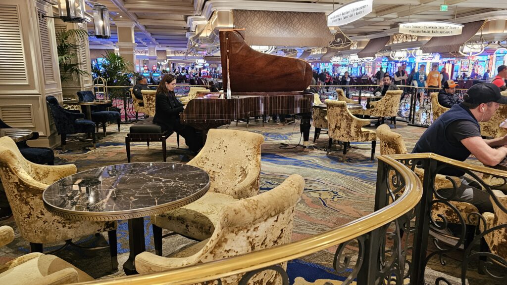 a woman sitting at a piano in a room with many chairs