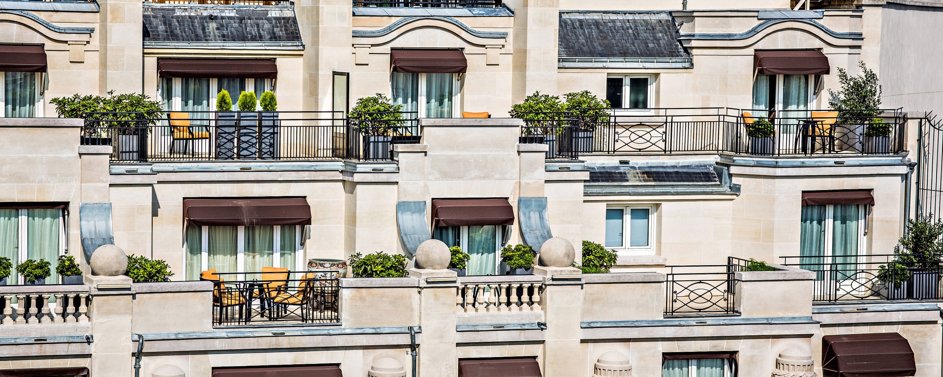 a building with a balcony and plants