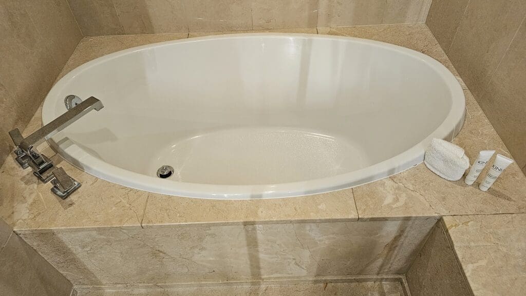 a white oval bathtub in a bathroom