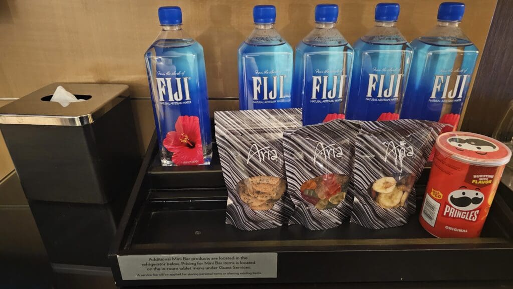 a group of bottles of water and bags of snacks