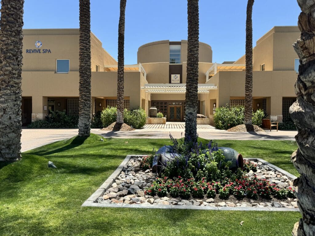 a building with palm trees and a large stone pot