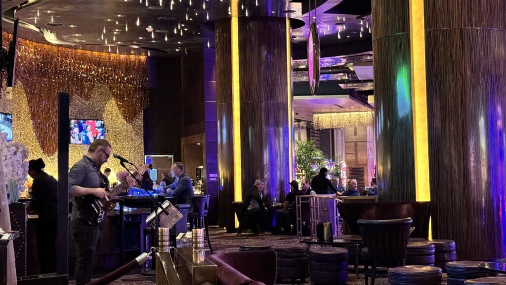 a group of people sitting at tables in a room with purple lights