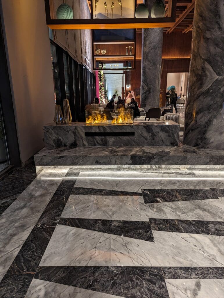 a marble floor with a fireplace and people in the background