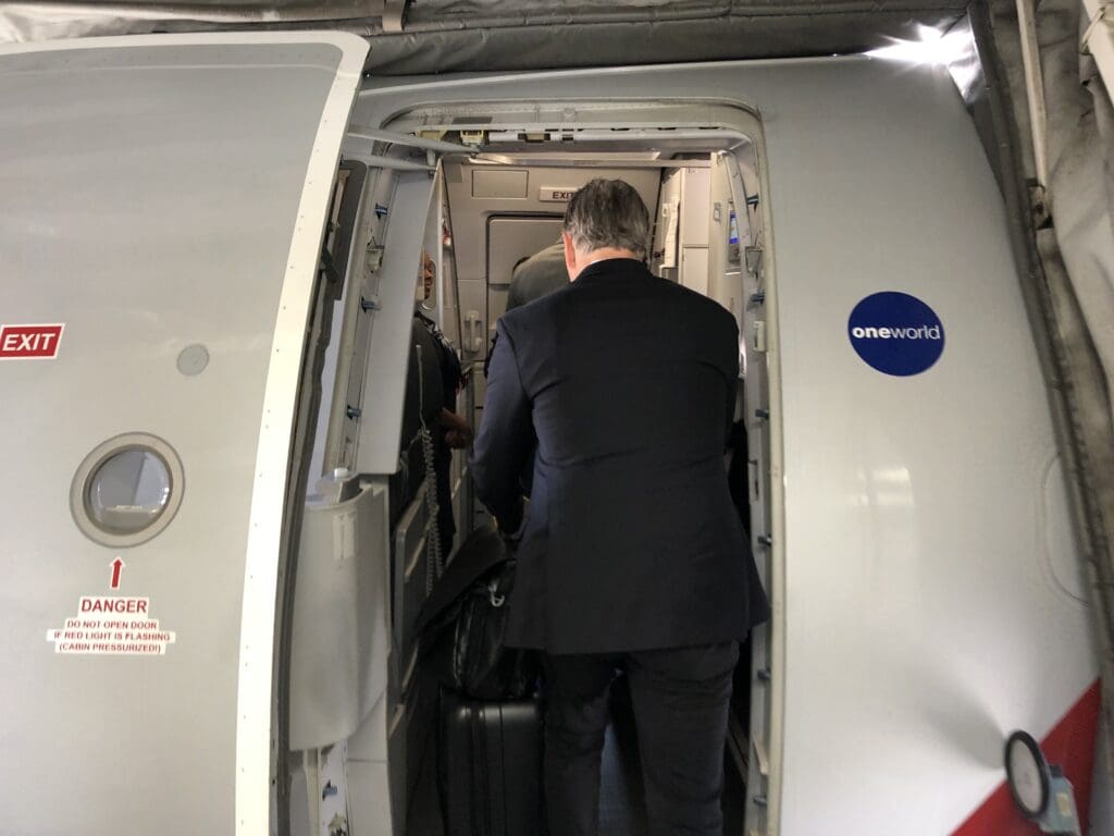 a man in a suit looking into an airplane door