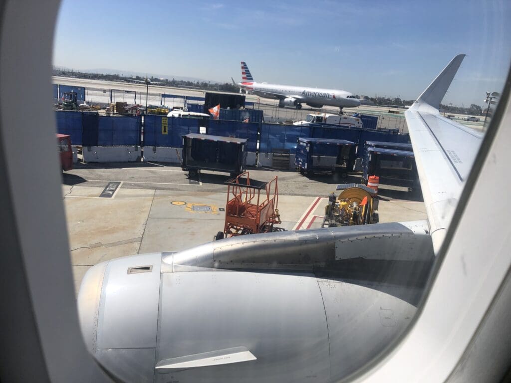 an airplane wing and a few vehicles on the runway