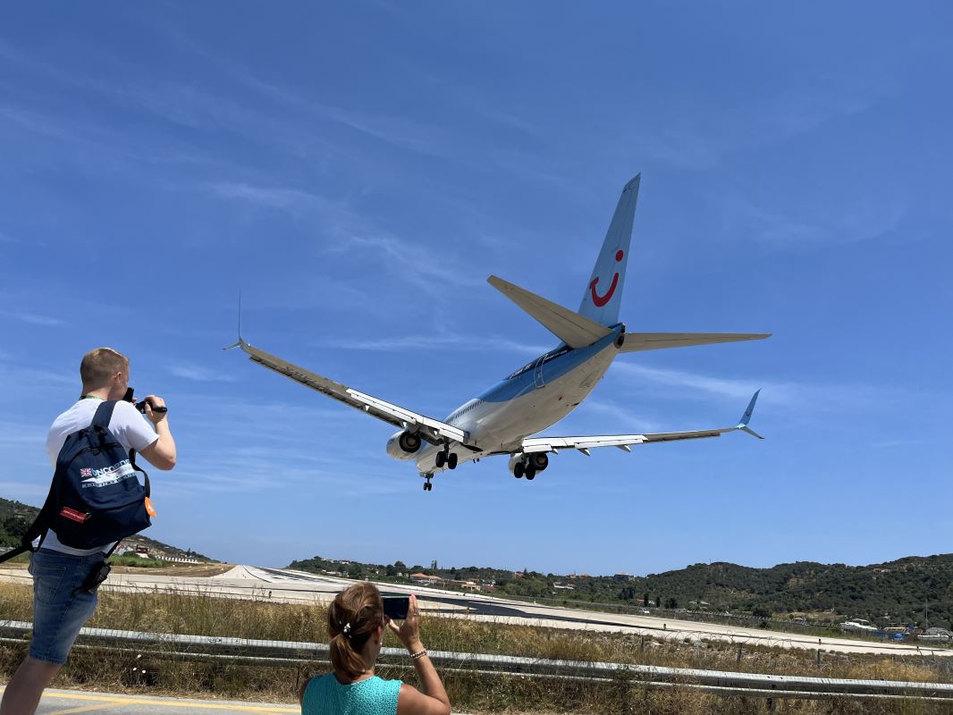 a plane taking a picture of a woman taking a picture of a plane