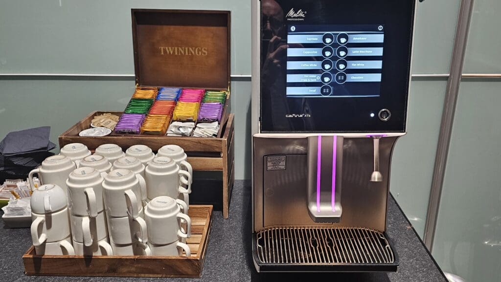 a coffee machine with a screen and a box of mugs