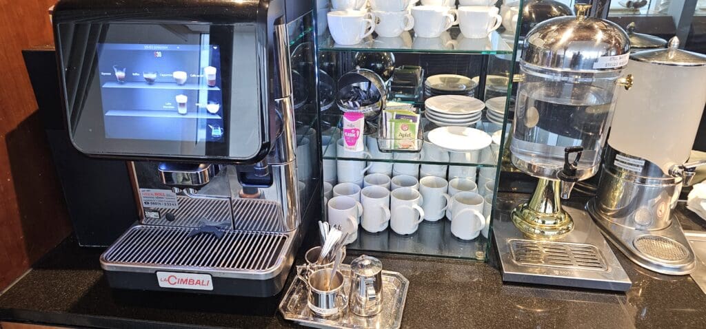 a coffee machine and cups on a shelf