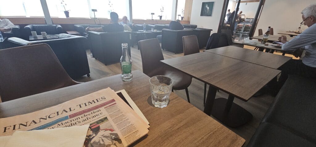 a glass and newspaper on a table