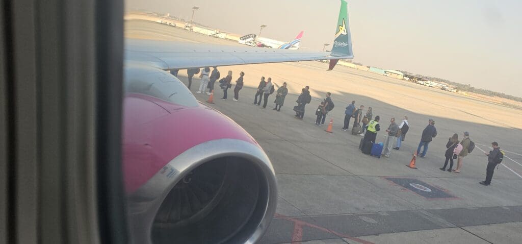 a group of people standing next to an airplane