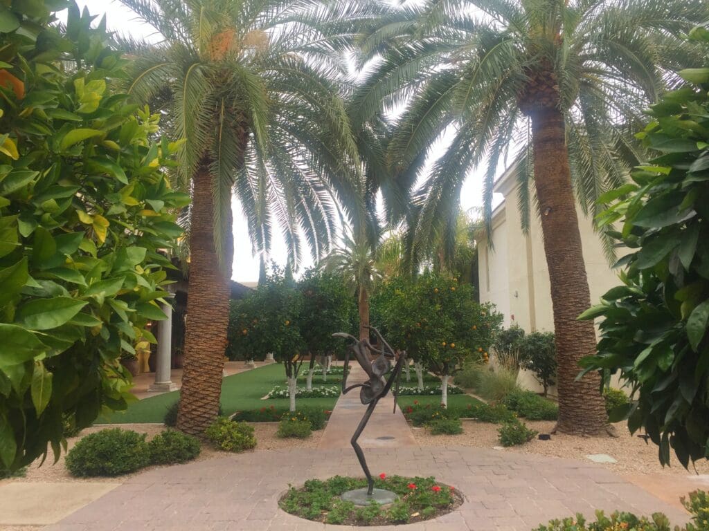 a statue in a courtyard with palm trees