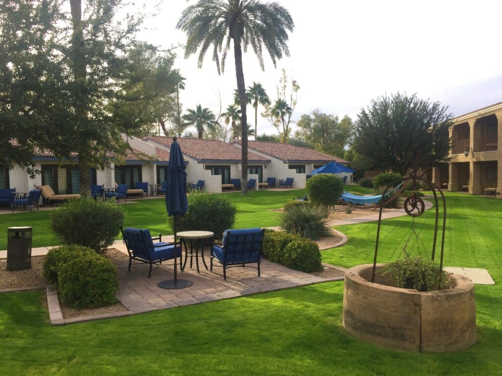 a patio area with chairs and a hammock in the middle