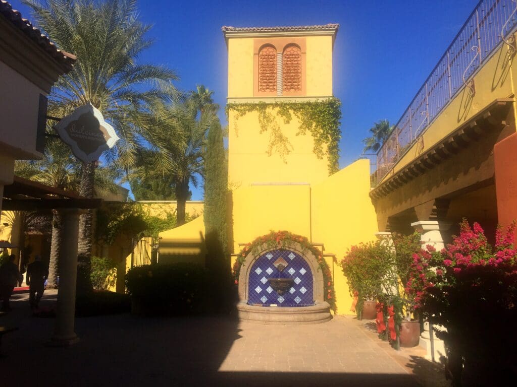 a yellow building with a blue and white fountain