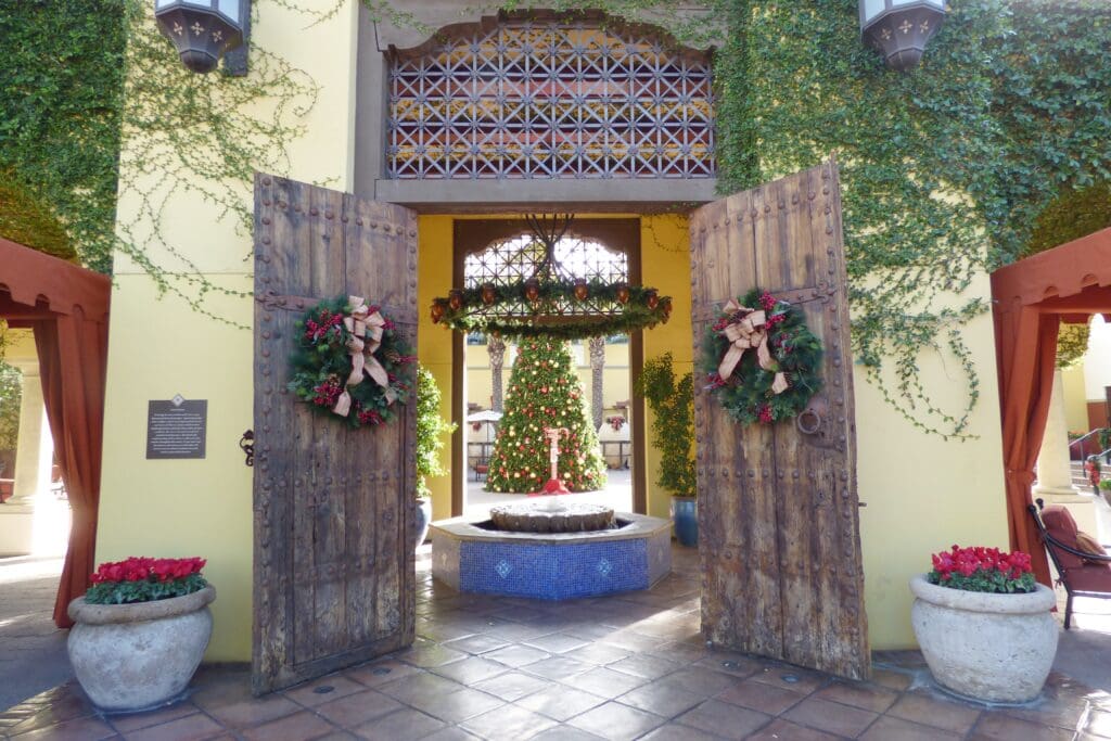 a door open to a fountain with a christmas tree