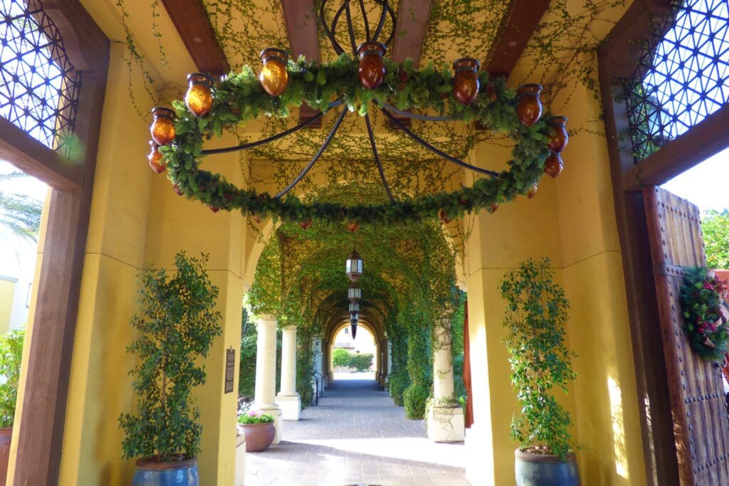 a long hallway with a chandelier and plants