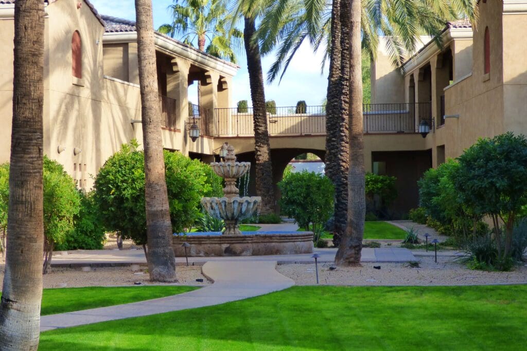 a fountain in a courtyard with palm trees