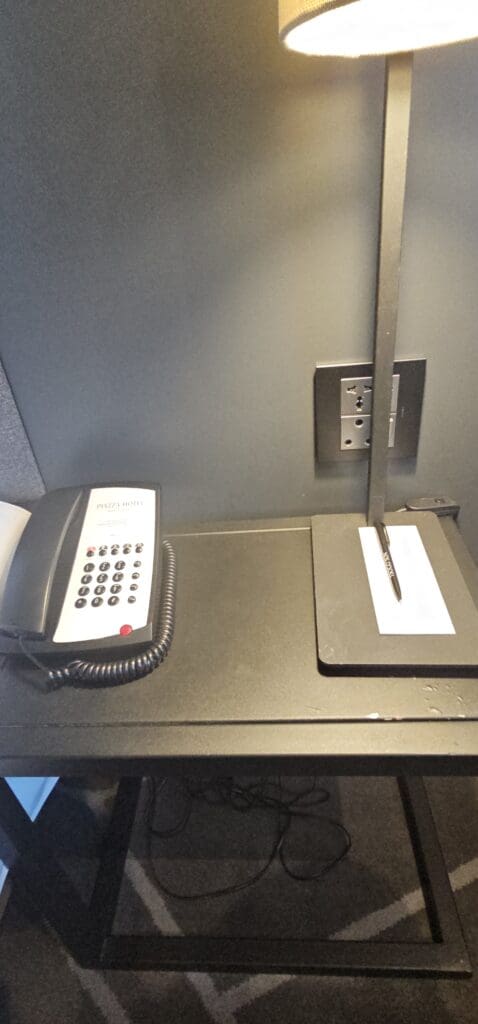 a telephone and stylus on a desk