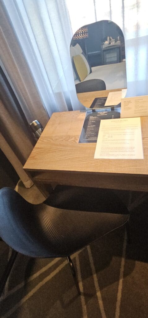 a table with a mirror and papers on it