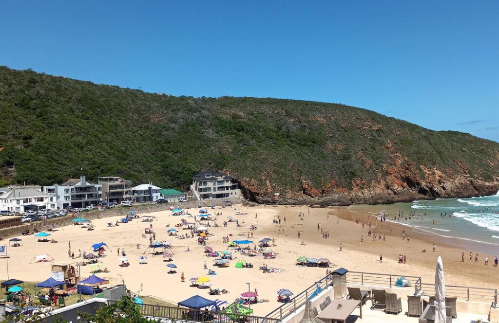 a beach with people and umbrellas