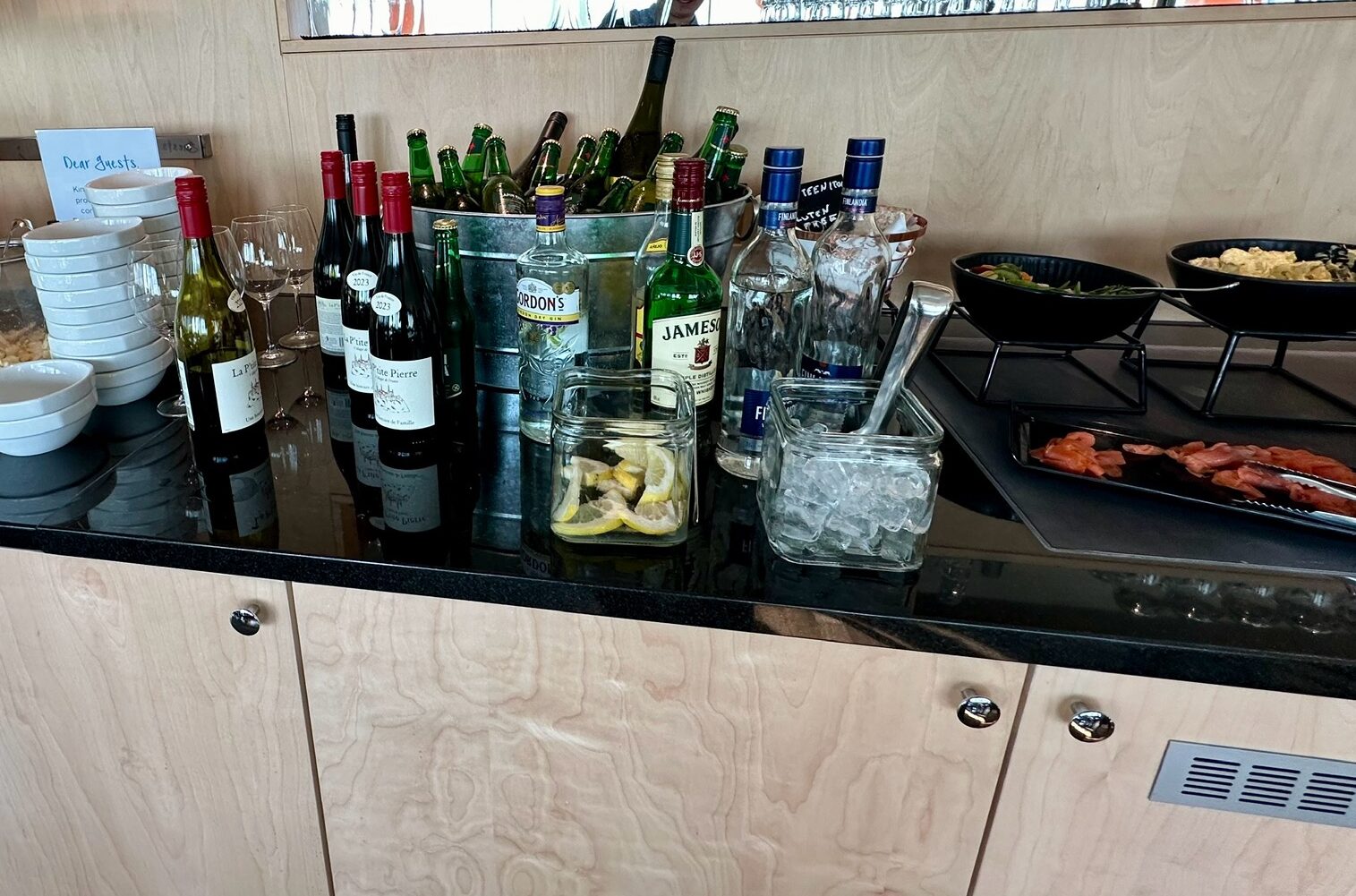 a counter with bottles of wine and food on it