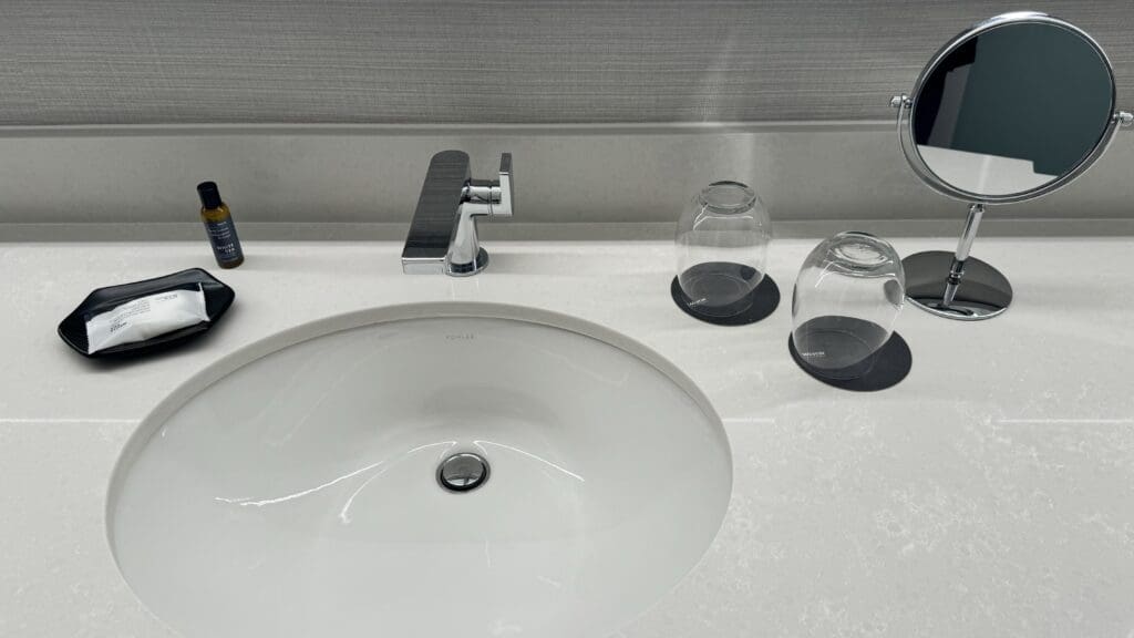 a sink with a faucet and two cups