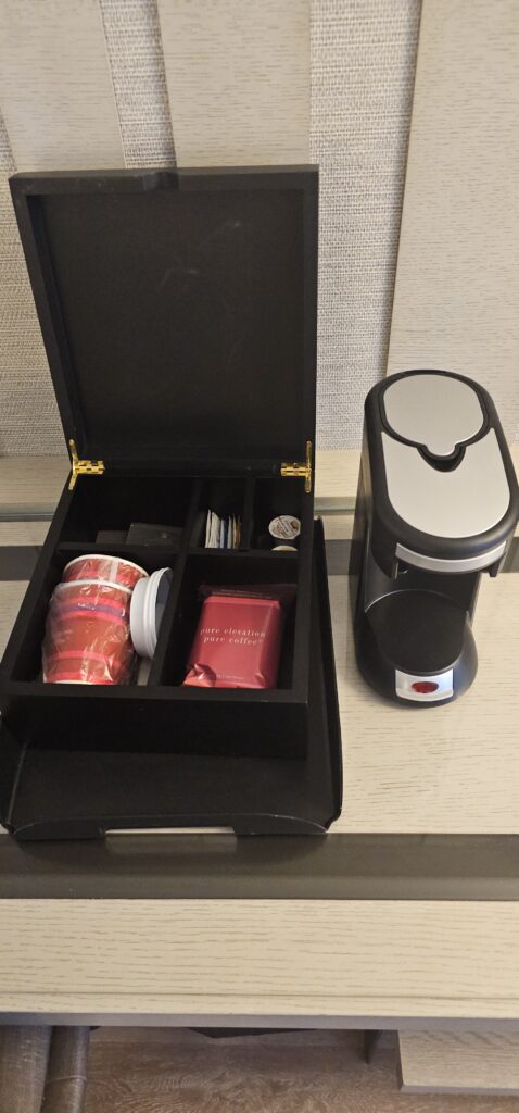 a black box with a container with a lid and a coffee cup inside