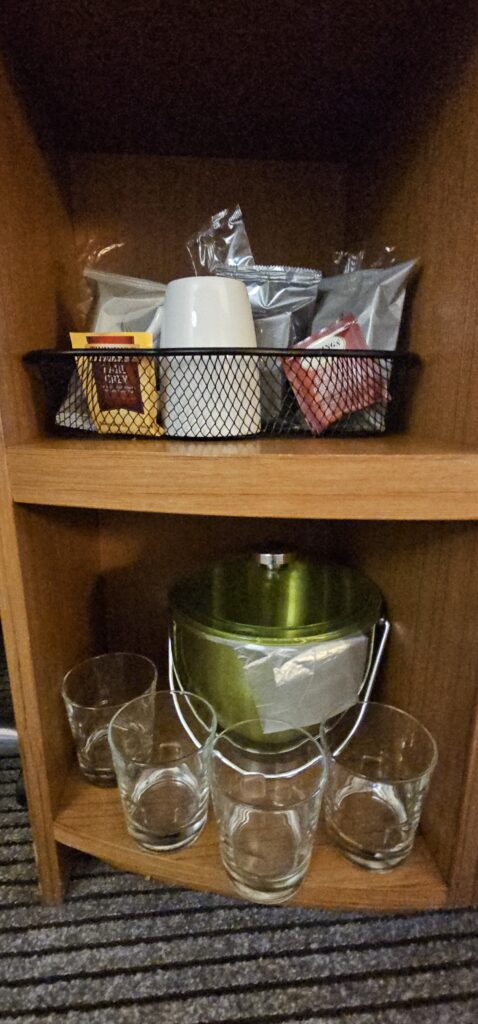 a shelf with a basket of coffee and tea bags