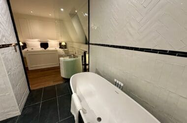 a bathroom with a tub and a bed at the Maison Delano Paris