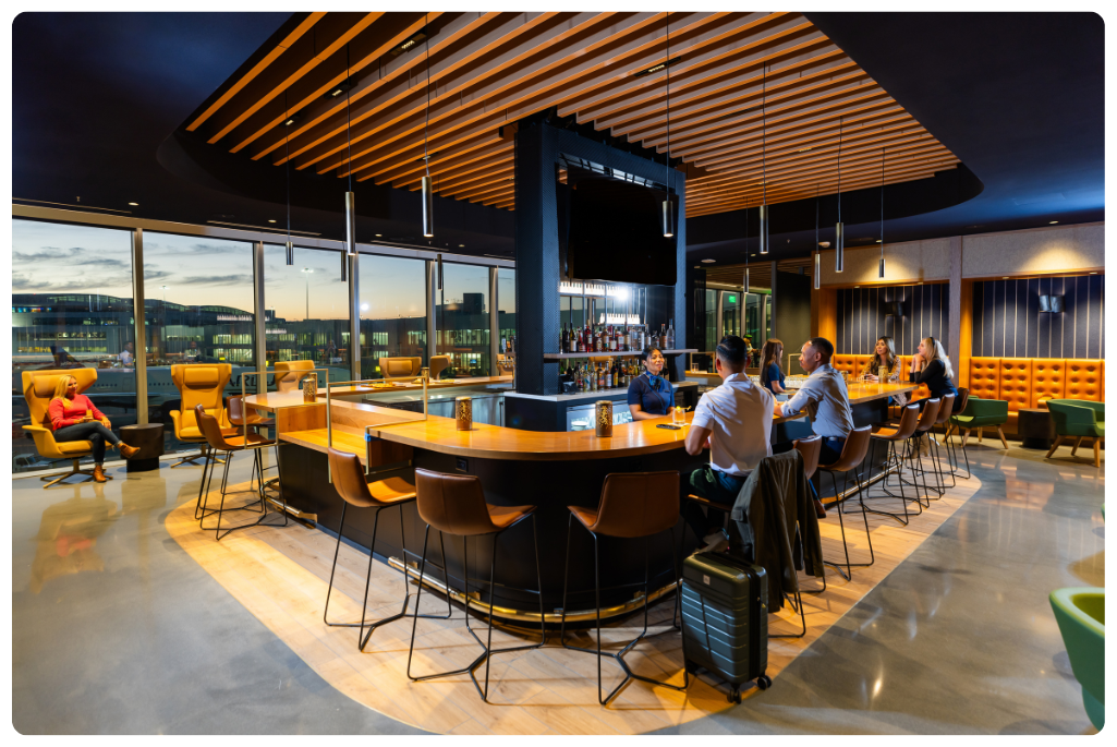 A group of people sitting at the bar at the Alaska Lounge San Francisco International Airport