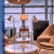 An airport lounge with upscale furniture including chairs and tables next to an assortment of colored bars that serve as decorative accents