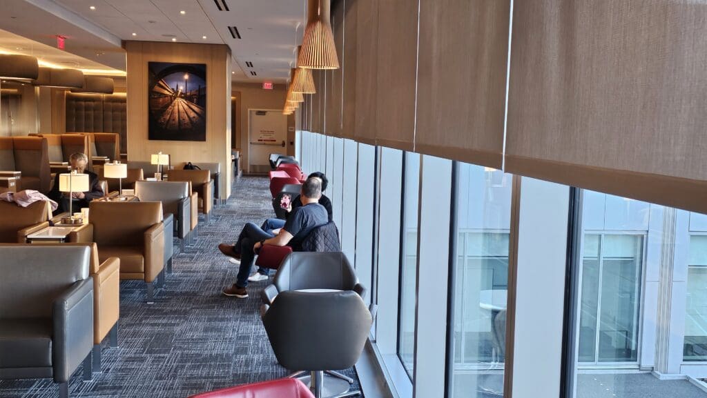 people sitting in a room with chairs and a window