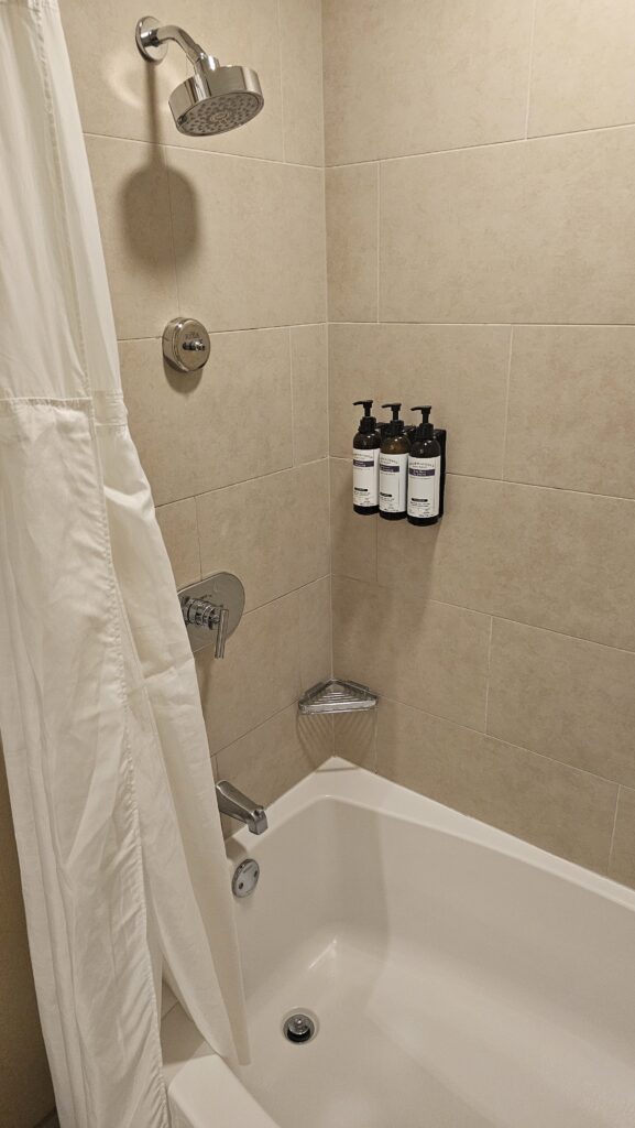 a shower with a white shower curtain